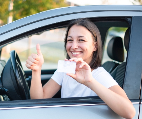 Eine Frau zeigt ihren Führerschein.